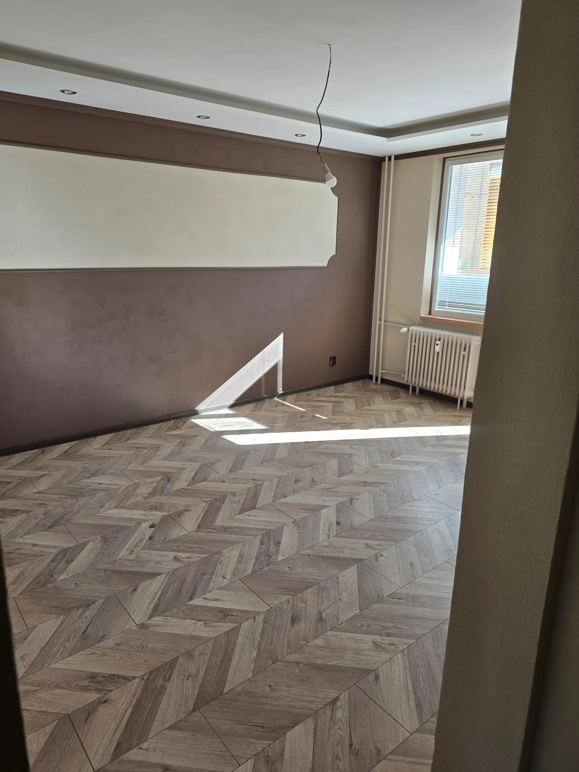 Október 2025 — izba po maľbe s dekoratívnym rámom na stene a novou podlahou