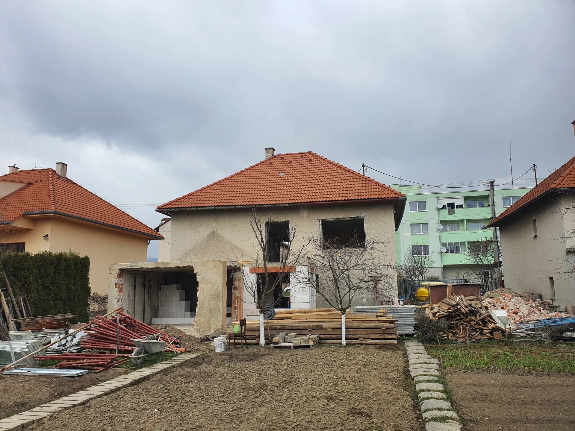 Apríl 2023 — pohľad zo záhrady: nová krytina, rozšírené otvory a rozostavaná prístavba