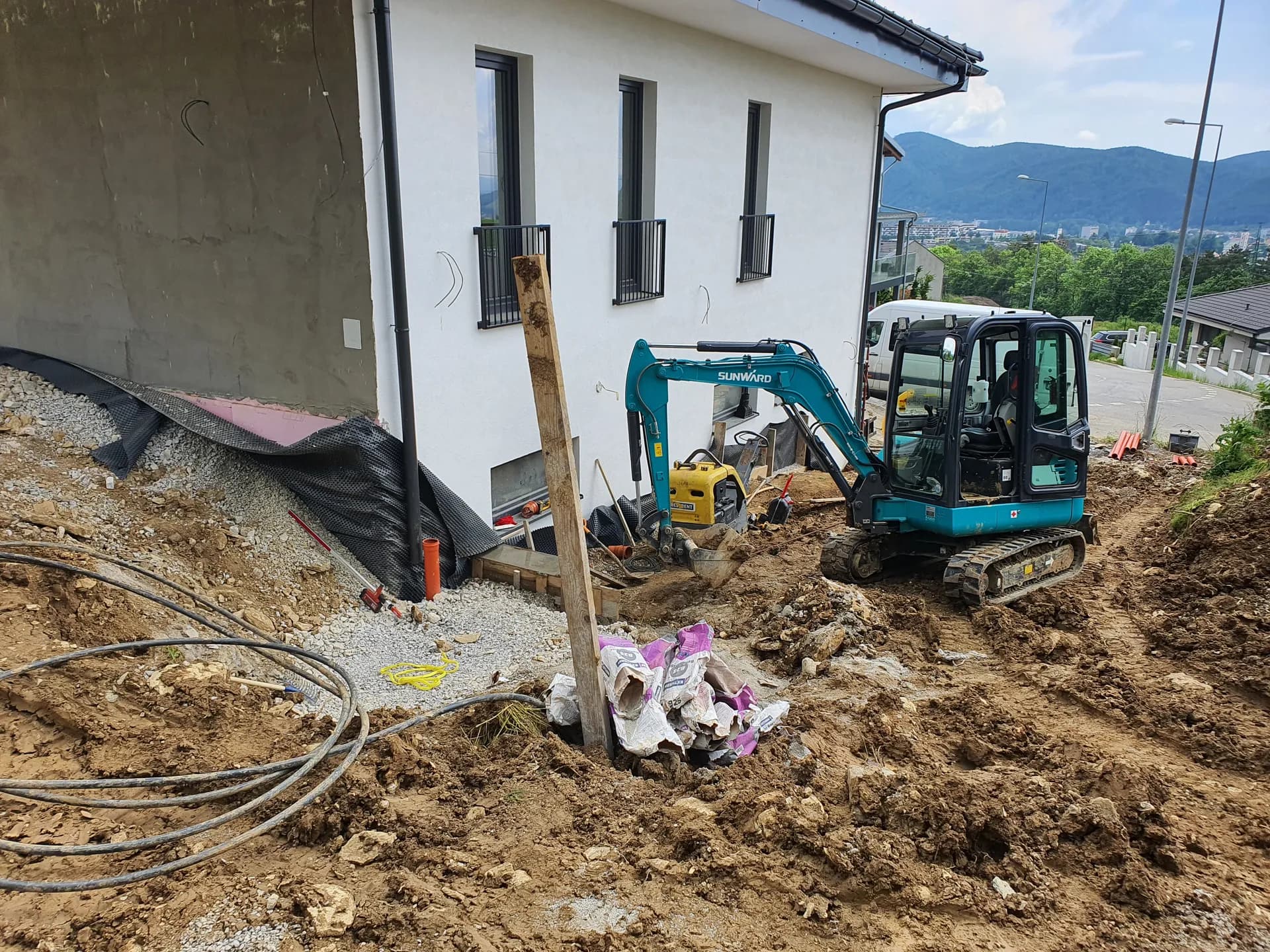 Máj 2023 — zemné práce pozdĺž obvodu a príprava podkladu pre spevnené plochy