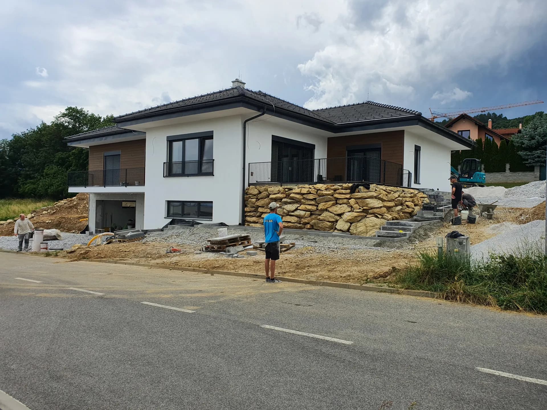 Jún 2023 — dokončený oporný múr, ukladanie vonkajšieho schodiska
