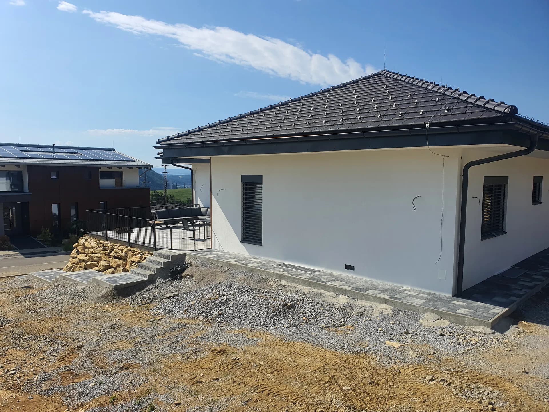 Júl 2023 — pohľad na terasu a dokončené spevnené plochy