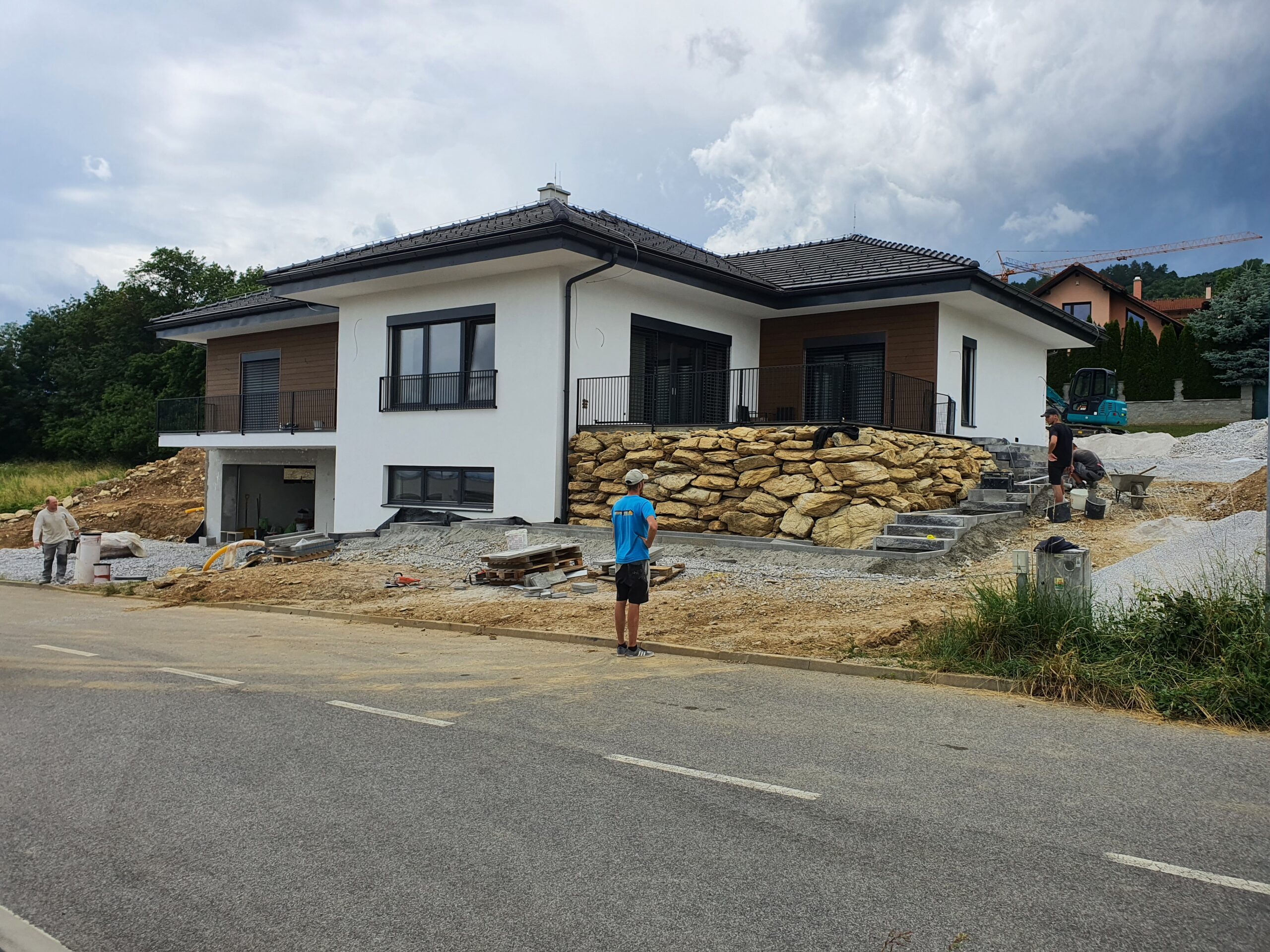 Novostavba luxusného rodinneho domu s moderným vzhľadom, stierkovaná fasáda, drevený obklad, plot z prírodného kameňa. Stavba domu na kľúč